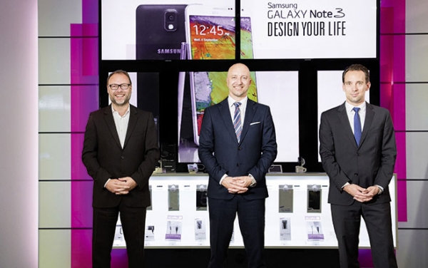 Die T-Mobile-Manager Jens Radszuweit (li.) und Daniel Daub (re.) mit Mark Winkler, B2BDirector Samsung, vor der neuen Digital-Signage-Lösung.