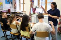  In der Schule wird ein mobiles Gerät mit einem Flachbildschirm und einer schwenkbaren Kamera aufgestellt.