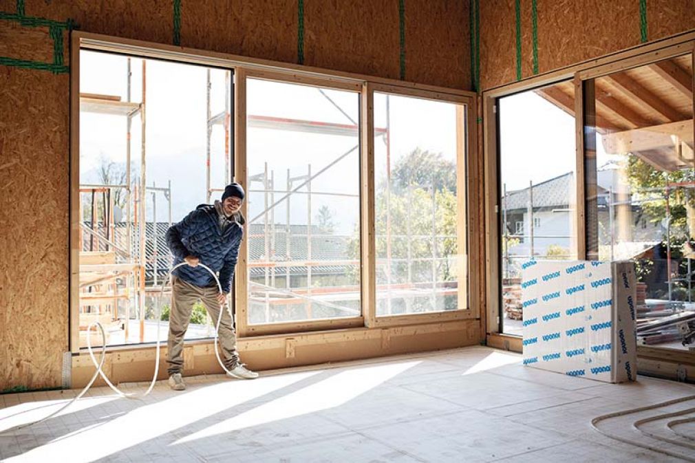 Foto: Der Bauherr packt auch mal selbst mit an: Im ganzen Haus wurde die Fußbodenheizung Uponor Klett verlegt.