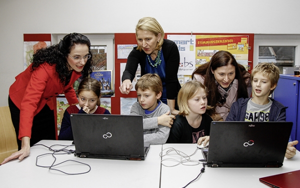 Tatjana Oppitz, Generaldirektorin IBM, Ulrike Huemer, CIO Stadt Wien, und  Barbara Novak, Präsidentin Wiener Bildungsserver, mit Kindern am Computer.