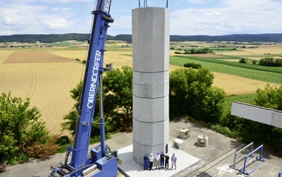 Foto: Die hohlen Beton-Doppelwand­elemente werden mithilfe eines Krans exakt aufeinandergestapelt und dann vor Ort mit Beton ausgegossen. 