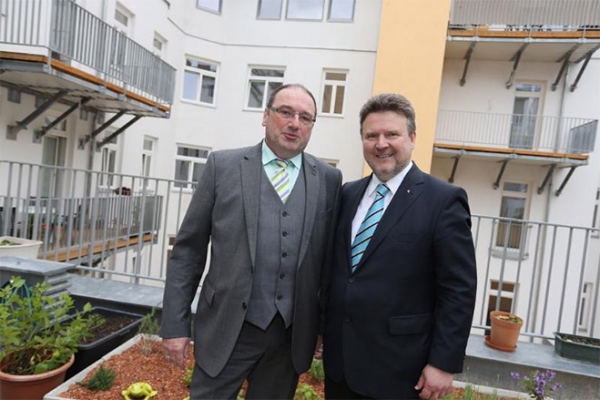 Foto: Bezirksvorsteher Gerhard Kubik (li.) und Wohnbaustadtrat Michael Ludwig (re.) im vorbildlich sanierten Wohnhaus Künstlergasse 14-16